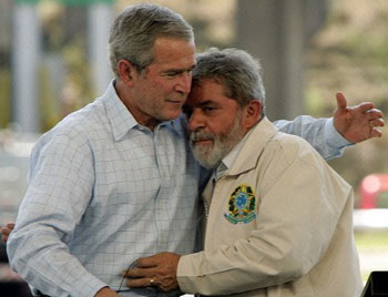 Bush visita o Brasil em 2007 e é abraçado pelo seu gerente Luis Inácio. Com a licitação de florestas o governo pretende entregar grandes extensões do nosso território aos gringos