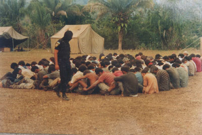 1995: camponeses presos em campo de concentração após longa resistência.