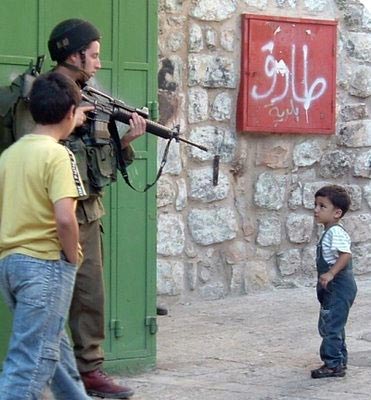 Soldado israelense aponta arma para criança palestina