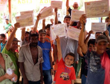 Camponeses exibem certificados de suas terras durante celebração do Corte Popular na área Canaã e Raio do Sol