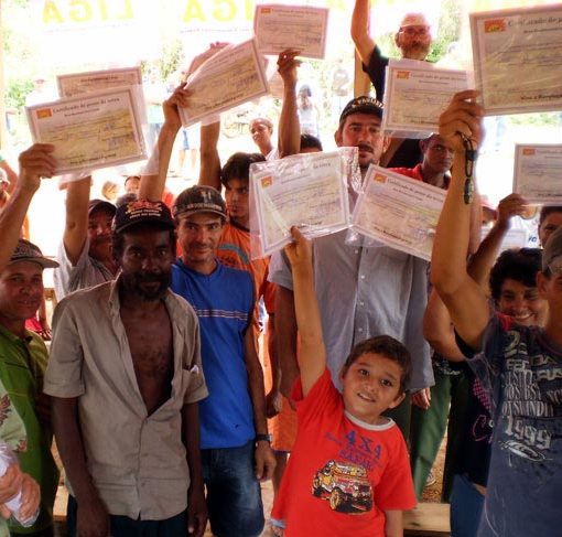 Camponeses exibem certificados de suas terras durante celebração do Corte Popular na área Canaã e Raio do Sol